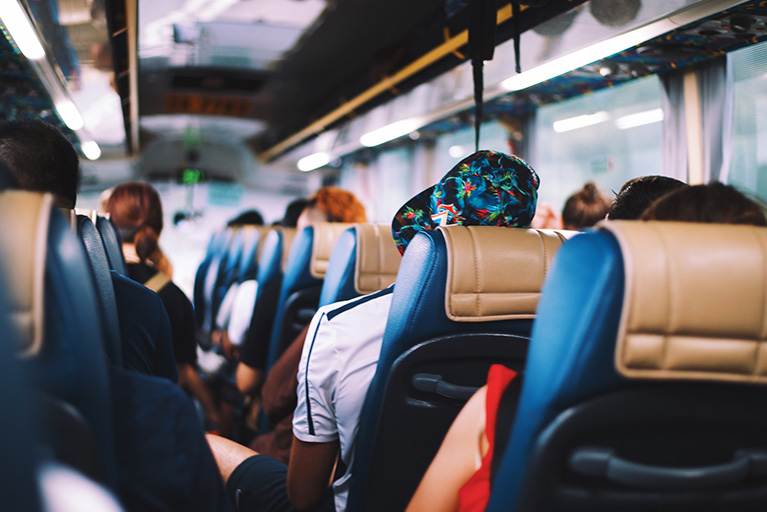 Bus mit Menschen: Meldepflicht bei Kopfläusen