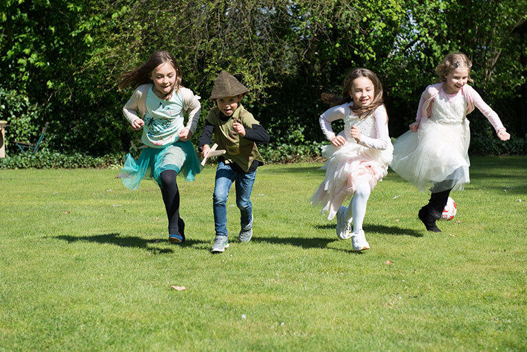 vier Kinder rennen über den Rasen