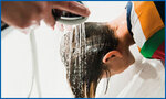 Kopf des Kindes über Badewanne mit Brause: Haare waschen