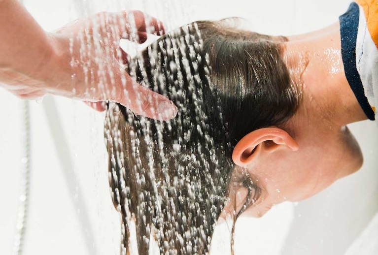 Mutter wäscht Haare von Jungen