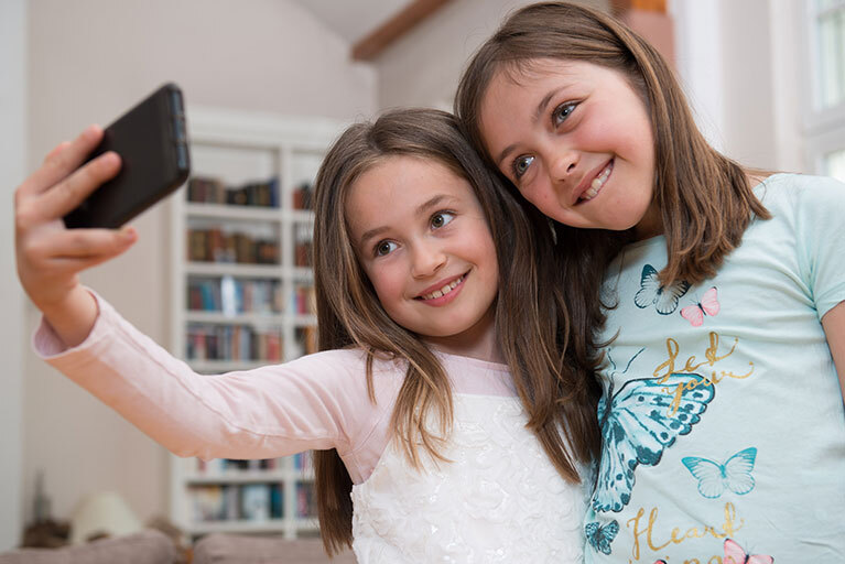 zwei Mädchen machen ein Selfie auf dem Smartphone